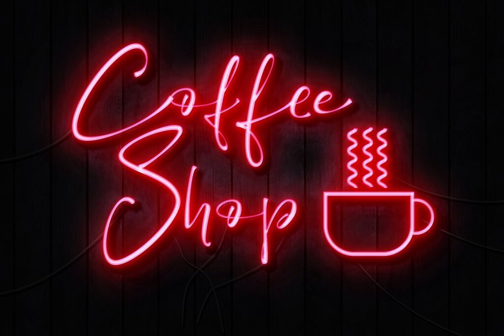 Red neon coffee shop sign with a steaming coffee cup