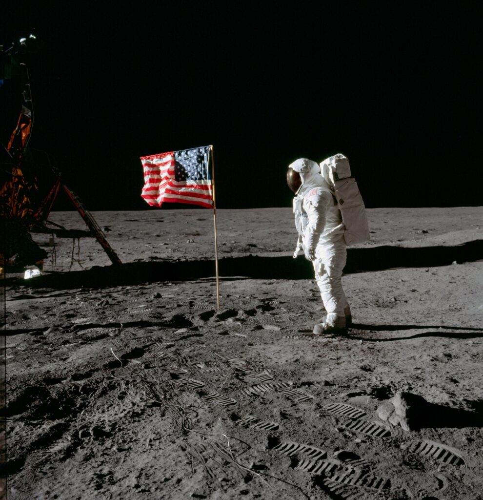 Astronaut standing beside American flag on the Moon during Apollo mission